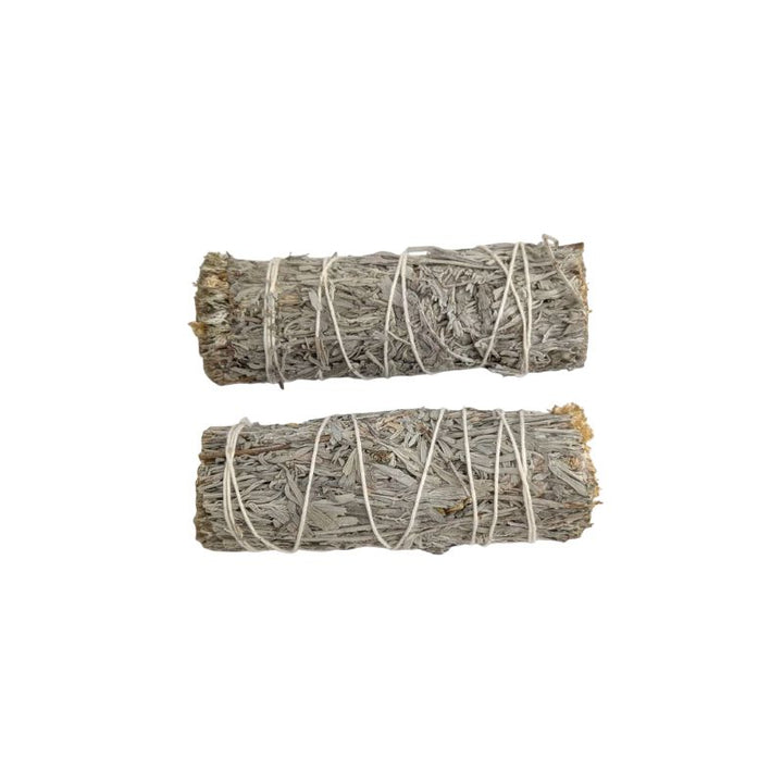 Two bundled blue sage smudge sticks wrapped in white string, displayed horizontally on a plain white background.