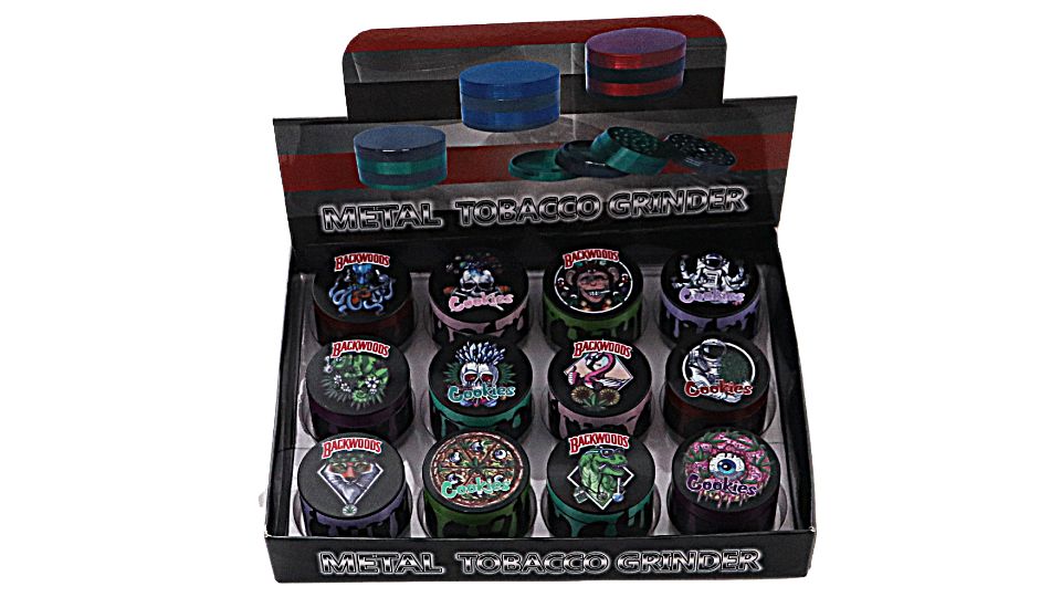 Display box of metal tobacco grinders with various designs on a white background