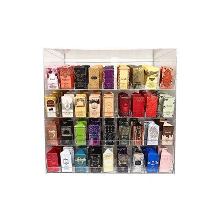 A clear acrylic 4-tier attar display rack filled with assorted colorful roll on boxes, on a white background.