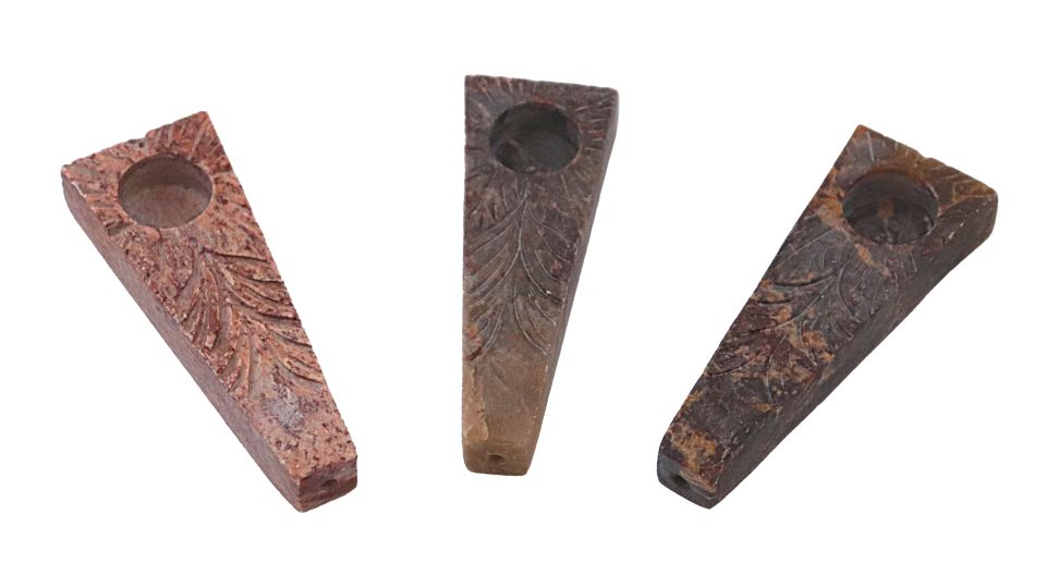 Stone tobacco pipes plank on a white background