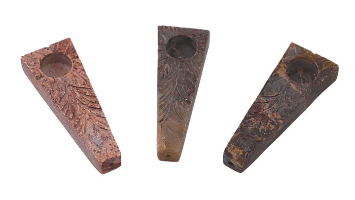 Stone tobacco pipes plank on a white background