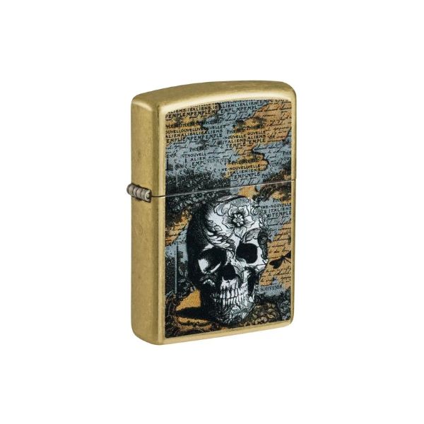 A brushed gold metal Zippo lighter with a vintage map background and a detailed skull illustration on the front.