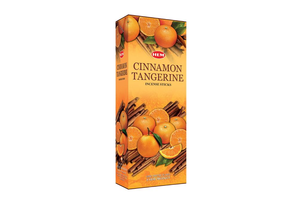 Box of HEM Cinnamon Tangerine incense sticks with cinnamon sticks and tangerines on a white background
